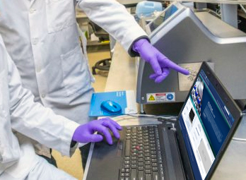 Laboratory workers looking at NFLIS website on a laptop